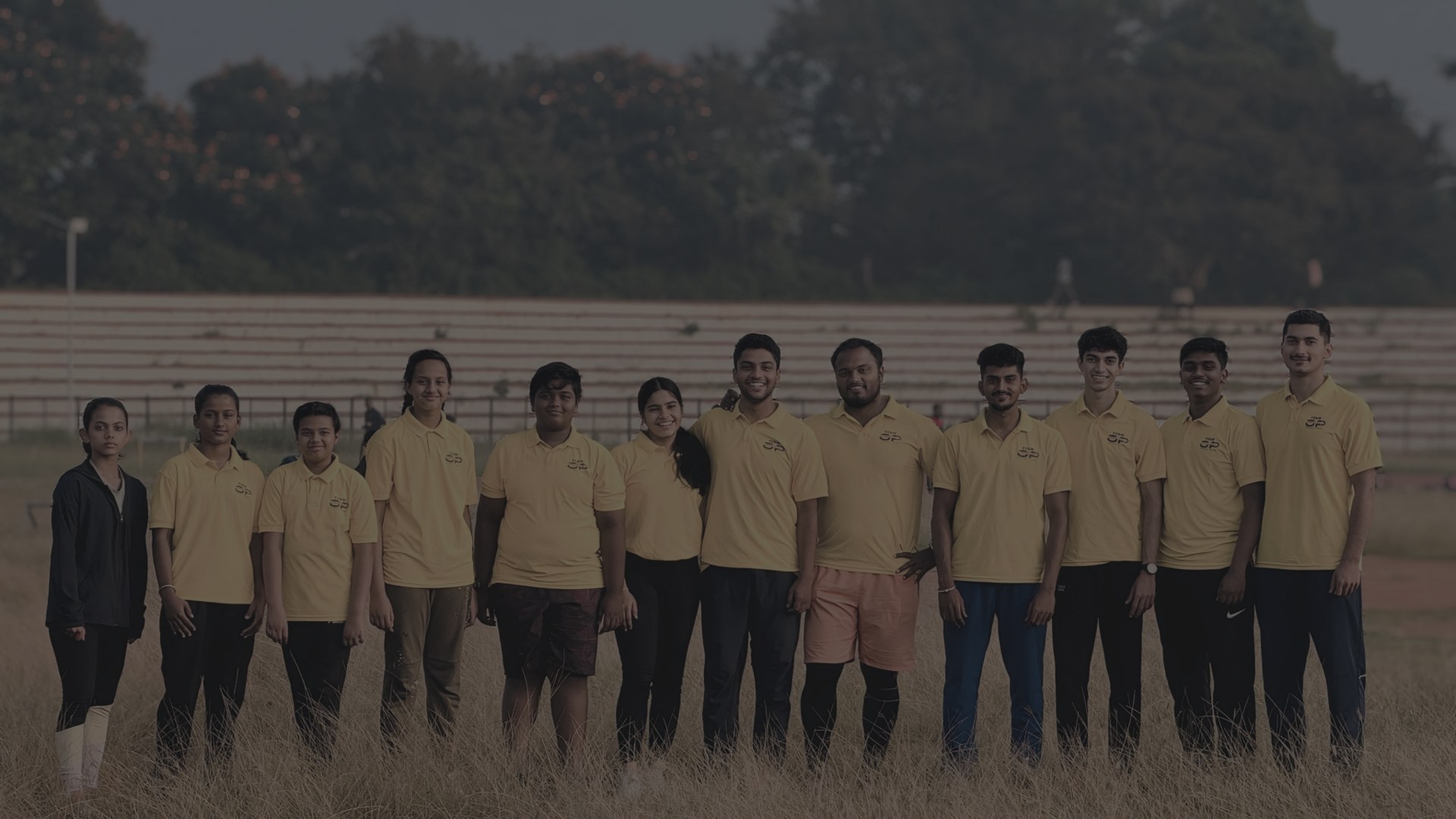 Radesh with a school sports team on the athletics field