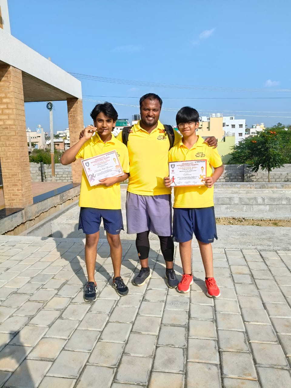 Radesh with school athletes holding medals and certificates